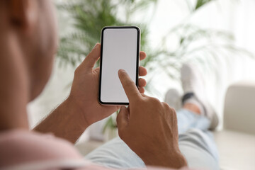 Man using mobile phone with empty screen indoors, closeup