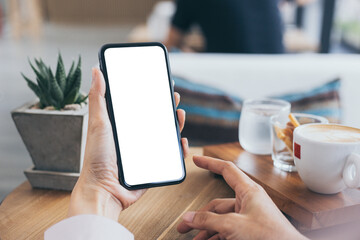 cell phone mockup blank white screen.woman hand holding texting using mobile on desk at coffee shop.background empty space for advertise.work people contact marketing business,technology