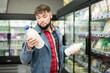 © JackF - Portrait of young man choosing fresh dairy products in grocery shop