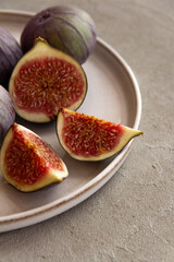 Wall Mural - Fresh figs on a plate on a light concrete background