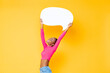 Smiling happy African American woman raising empty speech bubble isolated on colorful studio yellow background
