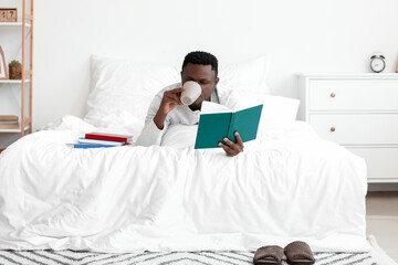 Wall Mural - African-American man reading book at home