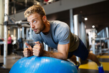 Fit Man Doing Fitness Exercise On Pilates Ball In Gym