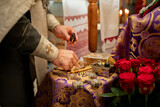 Fototapeta Paryż - holy oil in the priest's hands. the priest prepares for the baptism ceremony of the nebenk in a church