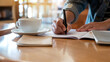 © Farknot Architect - Closeup image of a woman writing on a notebook on the table