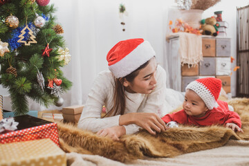 merry christmas and happy Holidays. mother held her daughter near the christmas tree and decorate the christmas tree indoors. the morning before Xmas. Portrait loving family close up.