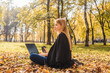 © Татьяна Максимова - Young businesswoman working on nature with coffee. Autumn park, sunny day.