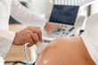 © Emma - Crop doctor examining pregnant belly with sonography equipment