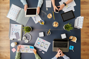 Wall Mural - business, people and team work concept - team of startuppers with gadgets and papers working at offi