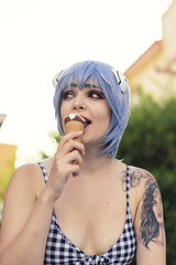 Canvas Print - Vertical shot of a European female with blue haor eating an ice-cream