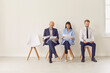 © Studio Romantic - Three candidates of different ages and ethnicities sitting on chairs waiting for job interview
