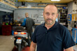 © auremar - man in the motorbike mechanic shop posing