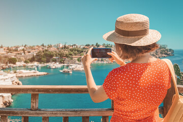 Wall Mural - female travel blogger takes high-quality pictures of the sea coast in a small resort town while on vacation.