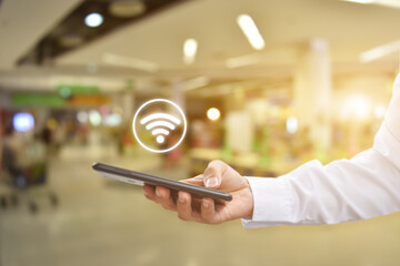 Canvas Print - man hand using mobile smartphone with wifi icon. idea for business communication social network.