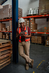 Wall Mural - Male factory worker scrolling through tracking deliveries on digital device standing in warehouse