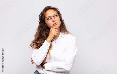Fotografía feeling thoughtful, wondering or imagining ideas, daydreaming and looking up to
