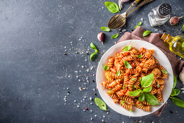 Wall Mural - Fusilli pasta with tomato sauce and basil. Traditional italian Fusilli pasta marinara, on dark background copy space