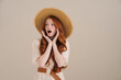Photo of shocked redhead girl in straw hat looking aside