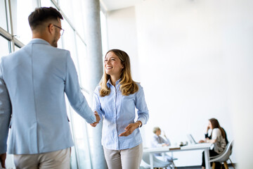 Poster - Young business partners making handshake in an office