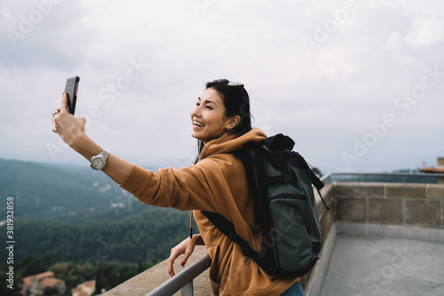 Cuadros en Lienzo Cheerful asian hipster girl recreating on vacations posing for selfie on destina