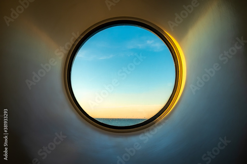 Cuadros en Lienzo Sunset ocean view of horizon seen from inside of a cruise ship cabin through a round circular window