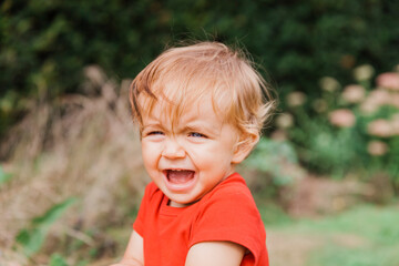 Wall Mural - Portrait of happy baby girl outdoors