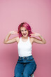 © LIGHTFIELD STUDIOS - excited young woman with colorful hair gesturing isolated on pink