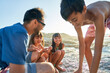 © Trevor Adeline/Caia Image - Happy family playing on sunny beach