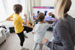 © Paul Bradbury/Caia Image - Family exercising at TV in living room
