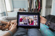 © Paul Bradbury/Caia Image - POV woman with digital tablet video chatting with friends on bed