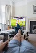 © Paul Bradbury/Caia Image - POV man watching soccer match on TV in living room