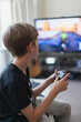 © Paul Bradbury/Caia Image - Boy playing video game at TV