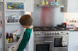 © Paul Bradbury/Caia Image - Boy looking inside kitchen refrigerator
