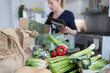 © Paul Bradbury/Caia Image - Woman unloading fresh produce from box in kitchen