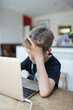 © Paul Bradbury/Caia Image - Boy with headphones homeschooling at laptop