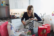 © Paul Bradbury/Caia Image - Woman unwrapping groceries in kitchen