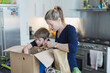 © Paul Bradbury/Caia Image - Mother and son unloading produce from box in kitchen