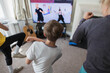 © Paul Bradbury/Caia Image - Mother and sons exercising online at TV in living room