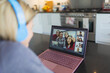 © Paul Bradbury/Caia Image - Woman with laptop video chatting with friends in kitchen