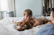 © Paul Bradbury/Caia Image - Cute boy cuddling with dog on bed