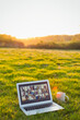 © Martin Barraud/Caia Image - Video chat on laptop in sunny grass