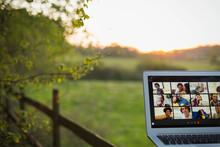 Friends Video Chatting On Laptop Screen On Rural Fence