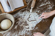 © Sam Edwards/Caia Image - Teenage girl drawing heart shape in flour on kitchen counter