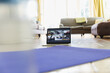 © Sam Edwards/Caia Image - Exercise class streaming on laptop screen behind yoga mat