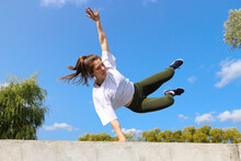A Girl Jumps Over A Wall On A Sports Street Playground