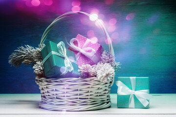 Wall Mural - Basket with frosty fir tree branches, gift boxes and defocused holiday lights. Christmas and New Year concept