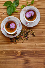 Sticker - Aesthetic shot of cups of tea with flowers inside on a wooden table