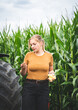 © Countrypixel - Maisanbau - junge Landwirtin vor einem Maisfeld freut sich über gut entwickelte Maiskolben.