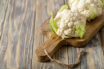 Two head of cauliflower cabbage on mango wood board