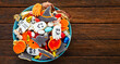 © RomanWhale studio - Halloween Jack o Lantern candy bowl with candy and halloween cookies Trick or Treat on black wooden background